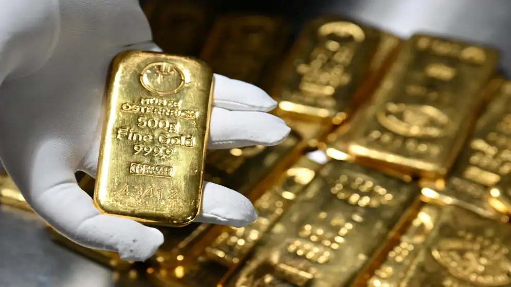 L’or recule de 0,7 % alors que le dollar s’apprécie après le maintien des taux américains Des lingots d'or empilés reflètent la baisse du cours de ce métal précieux alors que le dollar s'apprécie sur les marchés